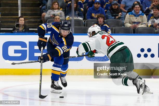 Brandon Saad of the St. Louis Blues and Jonas Brodin of the Minnesota Wild vie for control of the puck during the third period in Game Six of the...