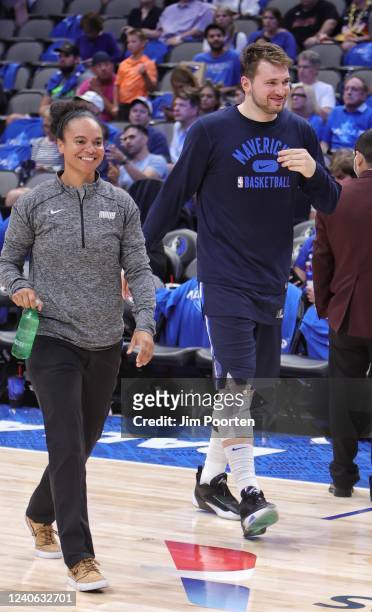 Assistant Coach Kristi Toliver walks on to the court with Luka Doncic of the Dallas Mavericks before the game against the Phoenix Suns during Game 4...
