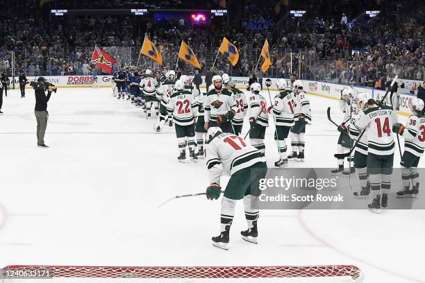 St. Louis Blues shake hands with the Minnesota Wild after defeating them in Game Six of the First Round of the 2022 Stanley Cup Playoffs at the...