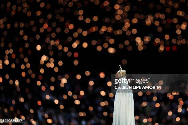 Statue of Our Lady of Fatima is pictured during the candlelight procession at the Shrine of Fatima, central Portugal, on May 12, 2022. - Thousands of...