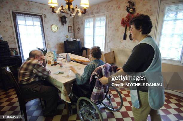 Photo prise le 05 décembre 2006 à Mézidon d'un couple de personnes âgées, Yvette et Maxime, et de Marilyne , employée de l'aide à domicile en milieu...