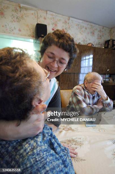 Marilyne, employée de l'aide à domicile en milieu rural , plaisante avec Yvette, assise dans son salon avec son mari Maxime le 05 décembre 2006 à...