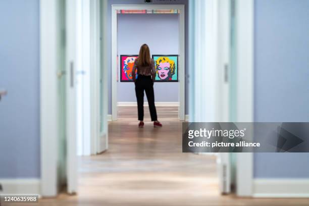 May 2022, North Rhine-Westphalia, Münster: A museum employee stands in front of the works "Marilyn Monroe " in the "Andy Warhol" exhibition at the...