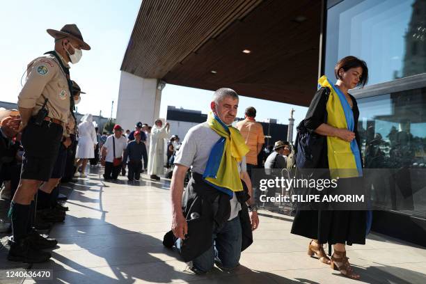 Pilgrims wearing Ukrainian flags take part in a procession at the Shrine of Fatima, central Portugal, on May 13, 2022. - Thousands of pilgrims...