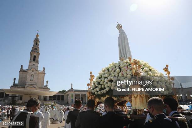 Statue of Our Lady of Fatima is carried during a procession at the Shrine of Fatima, central Portugal, on May 13, 2022. - Thousands of pilgrims...