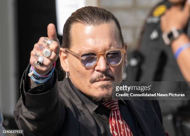 Johnny Depp gestures to his fans as he departs following a recess for the day outside court during the Johnny Depp and Amber Heard civil trial at...