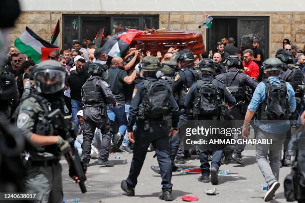Violence erupts between Israeli security forces and Palestinian mourners carrying the casket of slain Al-Jazeera journalist Shireen Abu Akleh out of...