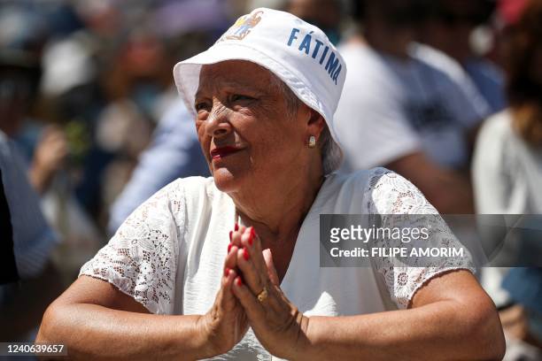 Pilgrim prays during a procession at the Shrine of Fatima, central Portugal, on May 13, 2022. - Thousands of pilgrims converged on the Fatima...