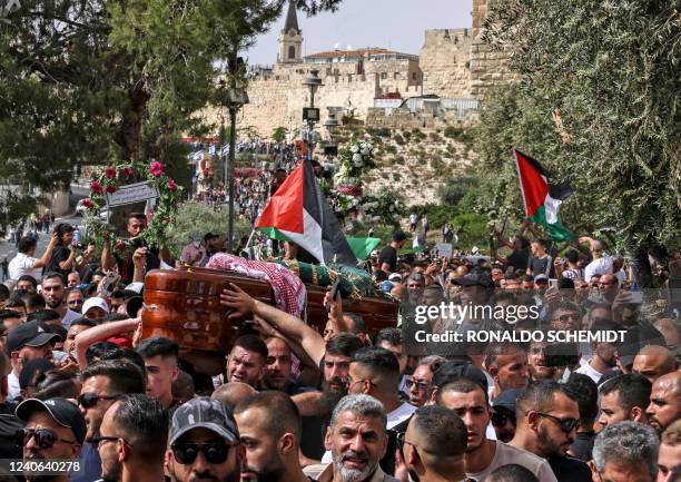 Palestinian mourners carry the casket of slain Al-Jazeera journalist Shireen Abu Akleh from a church toward the cemetary, during her funeral...