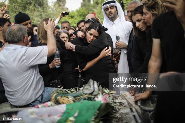 May 2022, Israel, Jerusalem: Palestinian mourners crowd around the grave of slain Al Jazeera reporter, Shireen Abu Akleh, at the Mount Zion Cemetery...