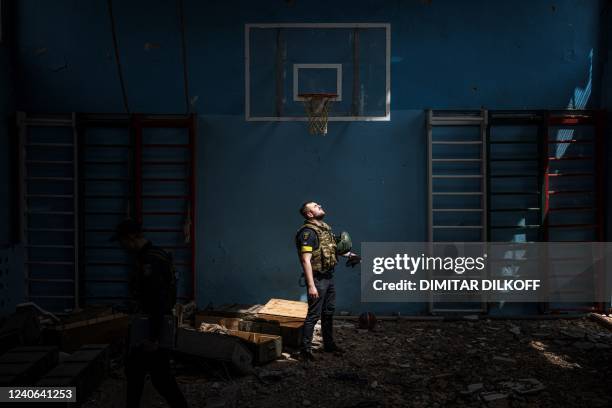 Ukrainian policeman stands inside a school gymnasium, where according to residents, Russian soldiers were based, in the village of Vilkhivka after it...