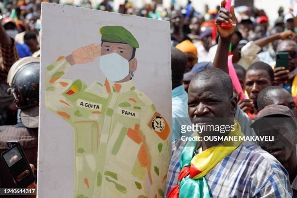 Supporter of Malian Interim President Assimi Goita holds up his image during a pro-Junta and pro-Russia rally in Bamako on May 13, 2022. - Several...