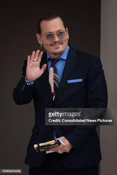 Johnny Depp waves to his fans during the afternoon recess outside court during the Johnny Depp and Amber Heard civil trial at Fairfax County Circuit...