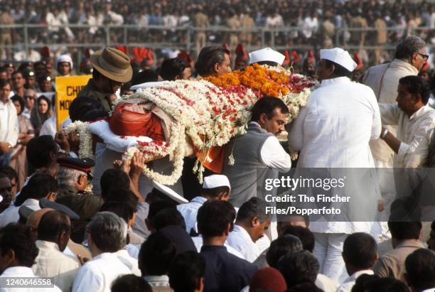 The body of Indira Gandhi being carried to the traditional funeral pyre during her state funeral following her death a few days earlier, at Raj Ghat...