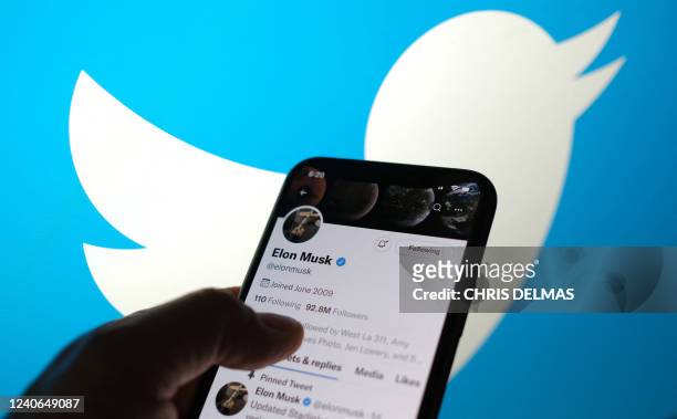 This illustration photo taken May 13 displays Elon Musk's Twitter account with a Twitter logo in the background in Los Angeles. Elon Musk sent mixed...