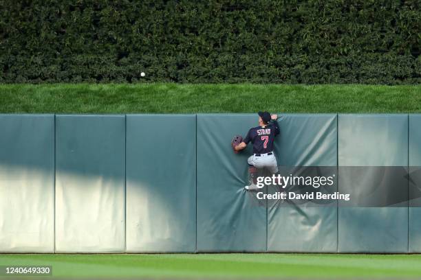 Myles Straw of the Cleveland Guardians climbs the center field wall as a ball hit by Jorge Polanco of the Minnesota Twins goes for a solo home run in...