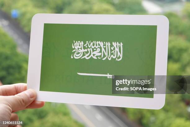 In this photo illustration, the Saudi Arabian flag is printed on a white card.
