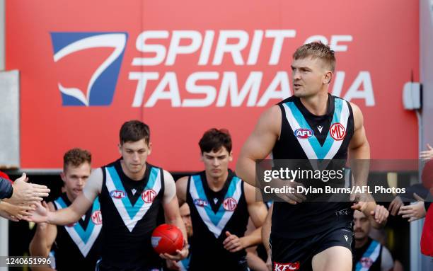 Ollie Wines of the Power leads his team on to the ground during the 2022 AFL Round 09 match between the North Melbourne Kangaroos and the Port...