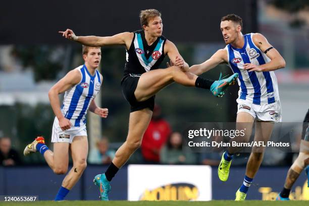 Xavier Duursma of the Power kicks the ball ahead of Lachie Young of the Kangaroos during the 2022 AFL Round 09 match between the North Melbourne...