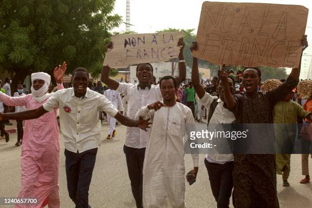 Demonstrators carry placards which read as 'No to France' as they take part in an anti-French protest in N'Djamena on May 14, 2022. - Several hundred...