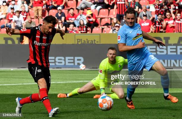 Leverkusen's Italian forward Lucas Alario scores the 1-0 against Freiburg's Dutch goalkeeper Mark Flekken during the German first division Bundesliga...