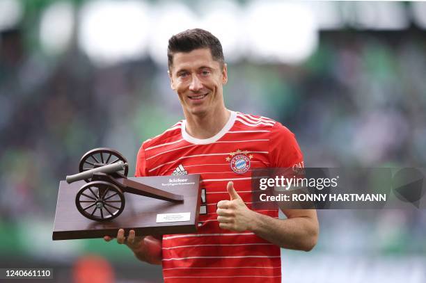 Bayern Munich's Polish forward Robert Lewandowski poses with the Top Scorer trophy, for finishing the season with the most goals scored in the German...