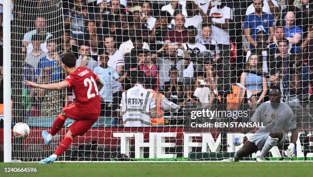 Liverpool's Greek defender Kostas Tsimikas shoots and scores past Chelsea's French-born Senegalese goalkeeper Edouard Mendy during the penalty...