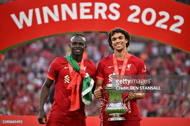 Liverpool's Senegalese striker Sadio Mane and Liverpool's English defender Trent Alexander-Arnold celebrate with the trophy after winning the English...