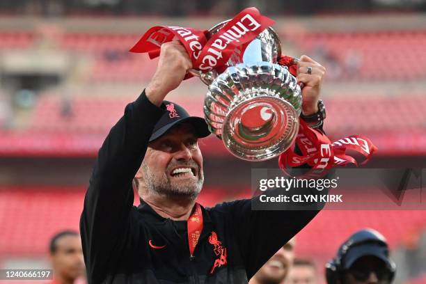 Liverpool's German manager Jurgen Klopp celebrates with the trophy after winning the English FA Cup final football match between Chelsea and...