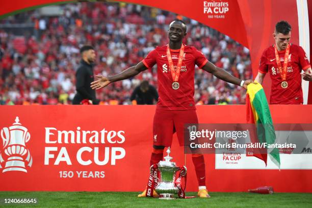 Sadio Mane of Liverpool poses with the trophy following his sides victory in a penalty shootout during The FA Cup Final match between Chelsea and...