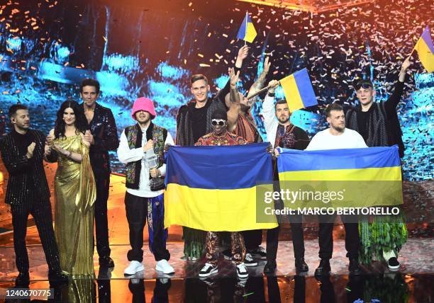 Members of the band "Kalush Orchestra" celebrate onstage with Ukraine's flags as Italian television presenter Alessandro Cattelan, Italian singer...