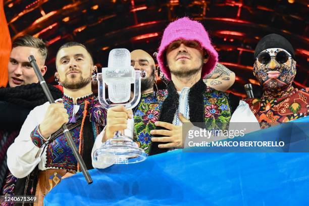 Members of the band "Kalush Orchestra" pose onstage with the winner's trophy and Ukraine's flags after winning on behalf of Ukraine the Eurovision...