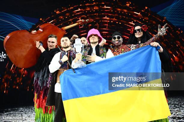 Members of the band "Kalush Orchestra" pose onstage with the winner's trophy and Ukraine's flags after winning on behalf of Ukraine the Eurovision...