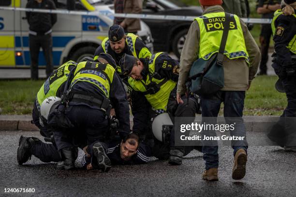 Counter-protester is arrested by the police during a Stram Kurs party election meeting in Hallunda on May 14, 2022 in Stockholm, Sweden. Far-right...