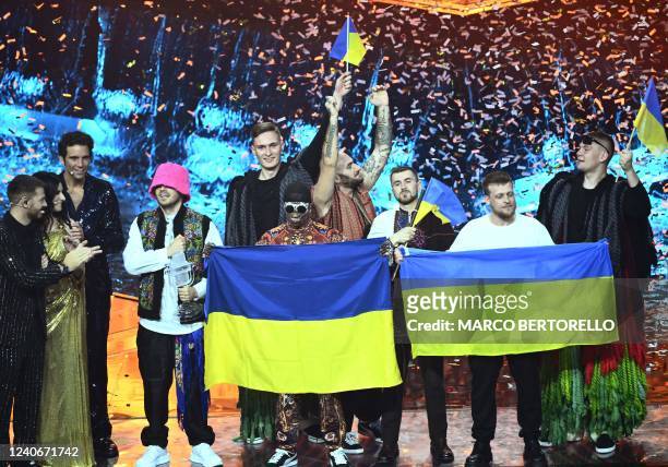 Members of the band "Kalush Orchestra" celebrate onstage with Ukraine's flags as Italian television presenter Alessandro Cattelan, Italian singer...