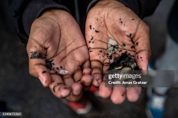 People collect the remains of a burned Koran that was set on fire during an election meeting for the Stram Kurs party in Hallunda on May 14, 2022 in...