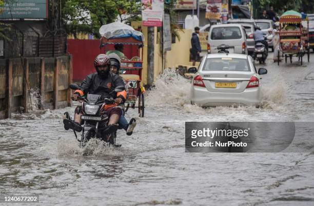 Commuters make their way on a waterlogged street after a heavy rainfall in Guwahati, Assam, India on 14 May 2022.