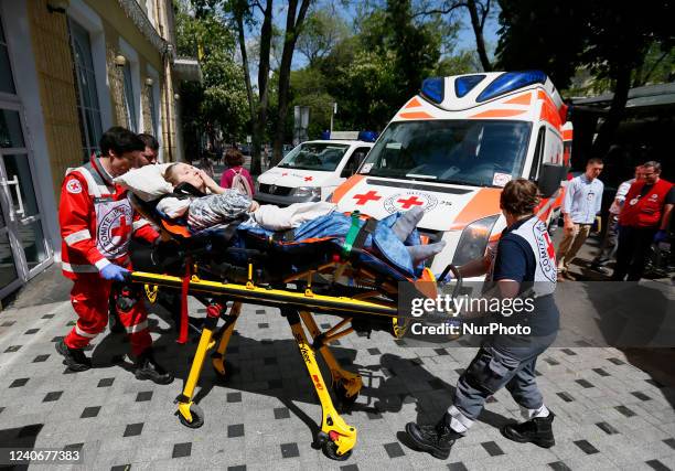 Red Cross staff carry on a stretcher a woman with disability, who the day before was evacuated from a frontline area of Mykolaiv, during evacuation...