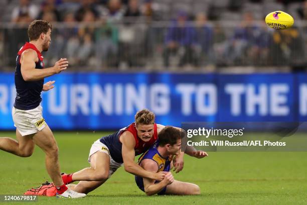 Luke Foley of the Eagles is tackled by Kade Chandler of the Demons during the 2022 AFL Round 09 match between the West Coast Eagles and the Melbourne...