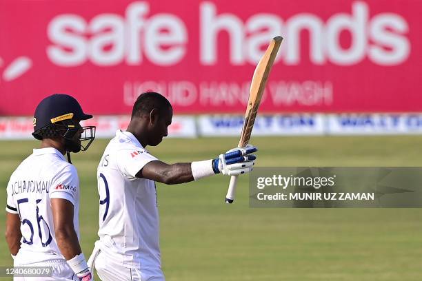 Sri Lanka's Angelo Mathews celebrates after scoring a century as his teammate Dinesh Chandimal watches during the first day of the first Test cricket...