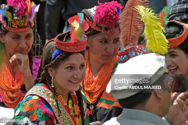 Kalash tribe women wearing traditional dresses arrive to take part in the 'Chilam Joshi' festival celebrating the arrival of spring at Bumburet...