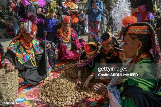 Kalash tribe women wearing traditional dresses arrive to take part in the 'Chilam Joshi' festival celebrating the arrival of spring at Bumburet...