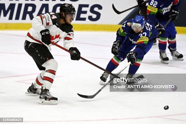 Canada's forward Maxime Comtois and Italy's defender Phil Pietroniro vie for the puck during the 2022 IIHF Ice Hockey World Championships preliminary...