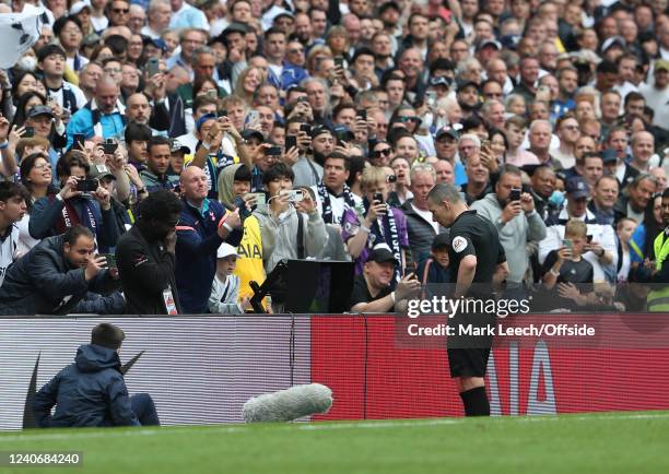 Referee Kevin Friend is photographed by supporters as he checks for a penalty decision on the VAR monitor during the Premier League match between...