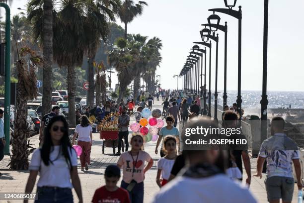 People walk along the Mediterranean sea waterfront in Lebanon's capital Beirut on May 15, 2022 during the parliamentary election. - Lebanon voted in...