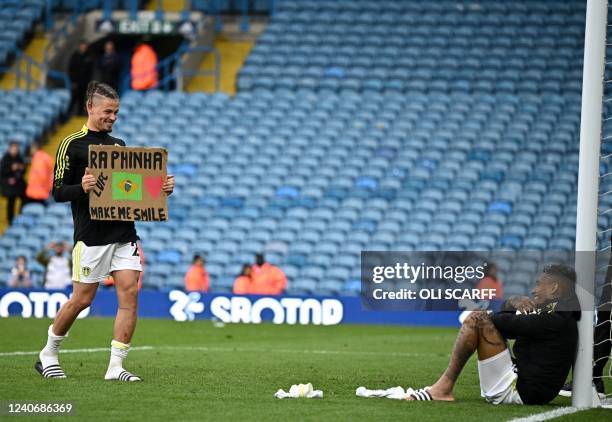 Leeds United's English midfielder Kalvin Phillips brings a placard over to Leeds United's Brazilian midfielder Raphinha Dias Belloli as players...