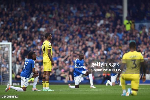 Brentford's English striker Ivan Toney stands as the other players take a knee prior to the English Premier League football match between Everton and...