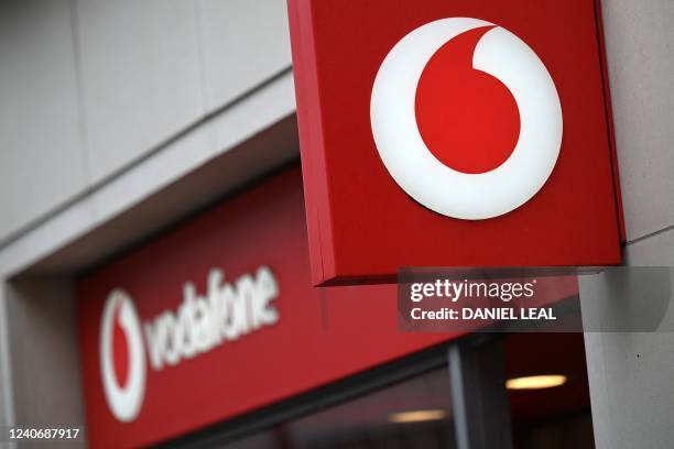 Branding for Vodafone is pictured outside a store in west London on May 15, 2022.