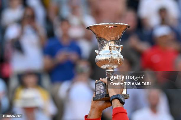 Serbia's Novak Djokovic celebrates with the winner's trophy after winning the final match of the Men's ATP Rome Open tennis tournament against...