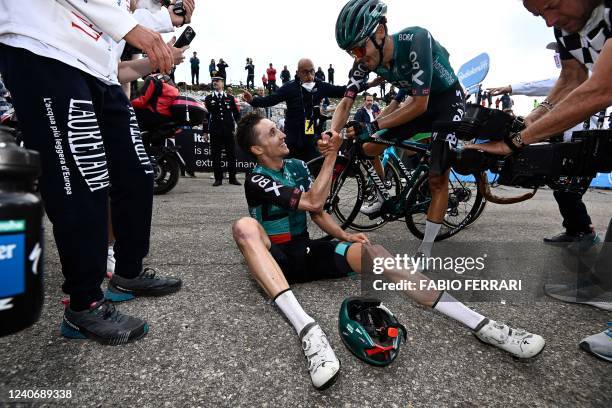 Team Bora's Australian rider Jai Hindley is congratulated by teammates after crossing the finish line to win the 9th stage of the Giro d'Italia 2022...